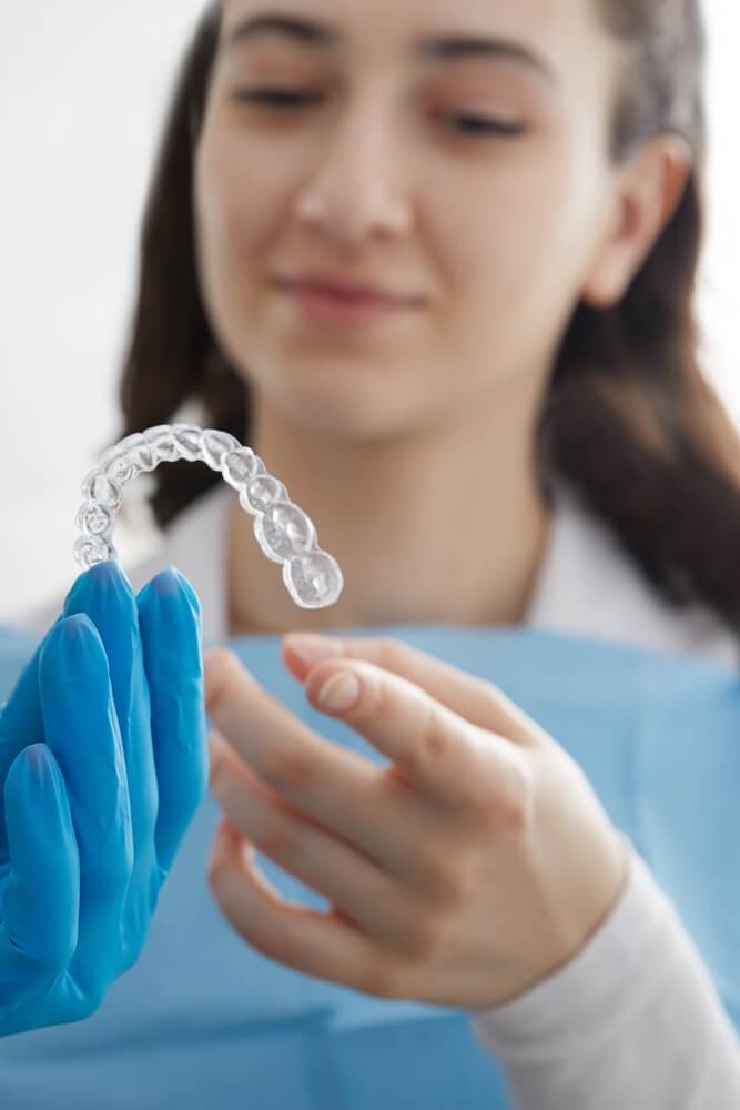 The dentist at Dental Logic is showing to patient the clear aligner model