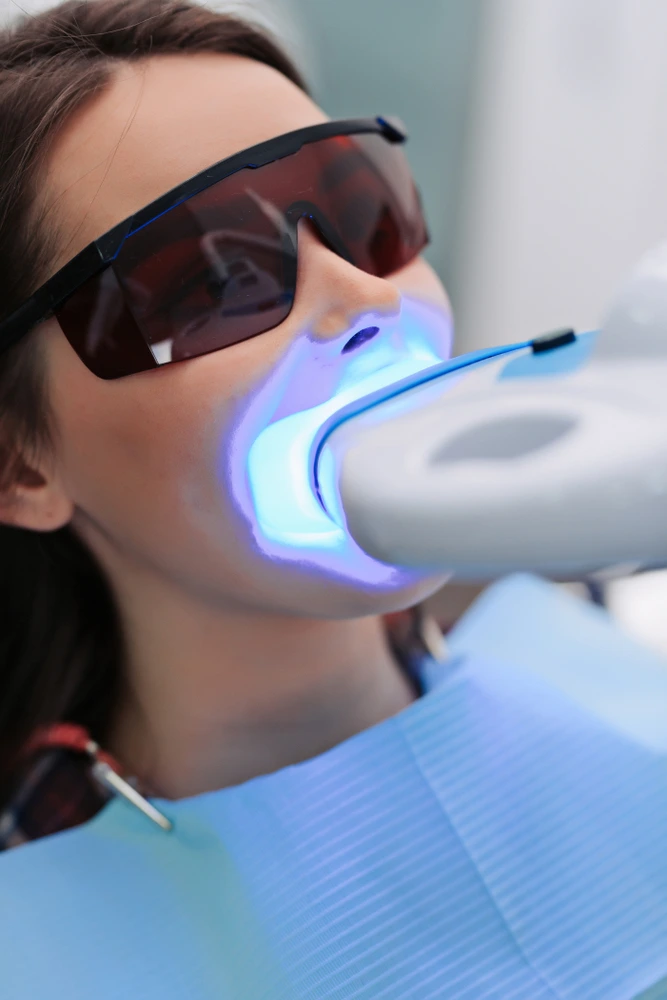The girl patient of Dental Logic is undergoing of teeth whitening treatment